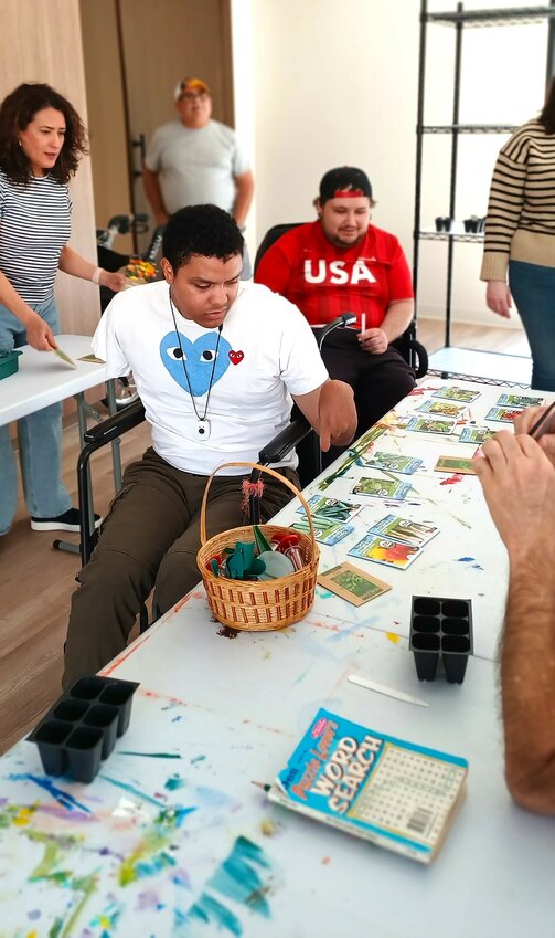 Residents plant seeds to add to the facility’s culinary gardens.