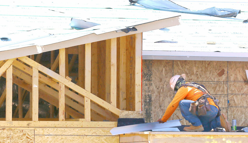 A construction worker continues installing a roof at a large housing development as the building boom kept going even through the coronavirus pandemic in April 2020 in Phoenix. The Arizona Legislature is close to a deal that could allow more housing be built to curb the state's housing shortage.