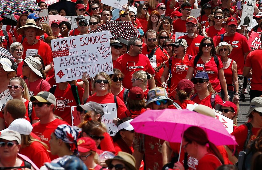 FILE - In this April 26, 2018, file photo, thousands march to the Arizona Capitol for higher teacher pay and public school funding on the first day of a state-wide teachers strike in Phoenix. Arizona Gov. Doug Ducey is apparently willing to risk further angering the state's teachers by forcefully backing a measure that would massively expand the state's private school voucher system. (AP Photo/Ross D. Franklin, file)