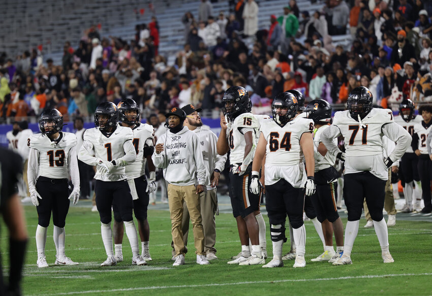 Desert Edge players and co-head coach Marcus Carter (center) stand in disbelief following a holding call that nullified what would have been the winning two-point conversion during the 5A title game Dec. 1 in Tempe.