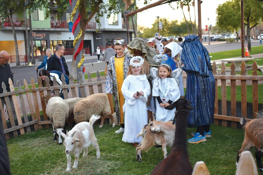 Children gathered around the petting zoo, a popular feature for Stroll in the Glow Saturday evening, Dec. 2. (Independent Newsmedia/Bob Burns)
