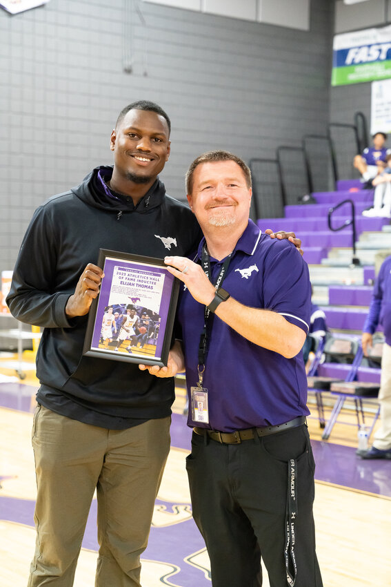 Former Sunrise Mountain basketball star Elijah Thomas, now an assistant coach with the Mustangs, receives his school athletic hall of fame plaque from Sunrise Mountain teacher and announcer Nick Rizer after being inducted Jan. 25.