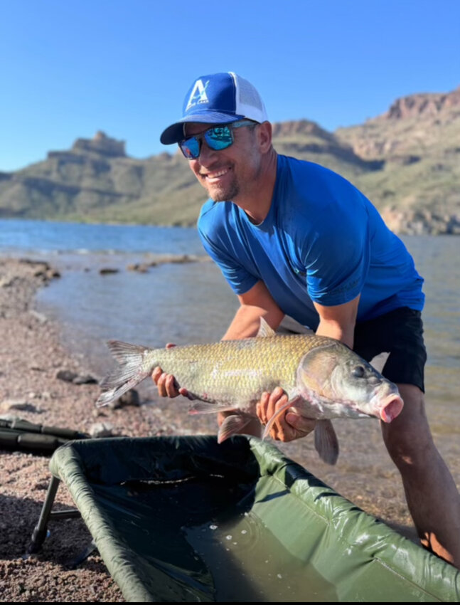 Apache Lake Marina and Resort employee Robert Howard holds a Buffalo carp fish.
