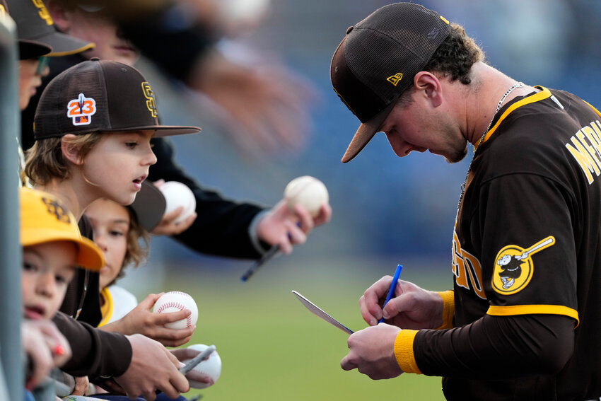 San Diego Padres&rsquo; Jackson Merrill signs an autograph before a spring training game against the Chicago Cubs Friday, March 3, 2023, at the Peoria Sports Complex. (The Associated Press/Charlie Riedel)
