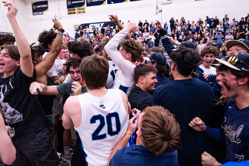 Casteel players and fans celebrate securing the boys basketball program's first trip to a state final game, following a 67-60 double overtime win over Canyon View Feb. 28 in Queen Creek.