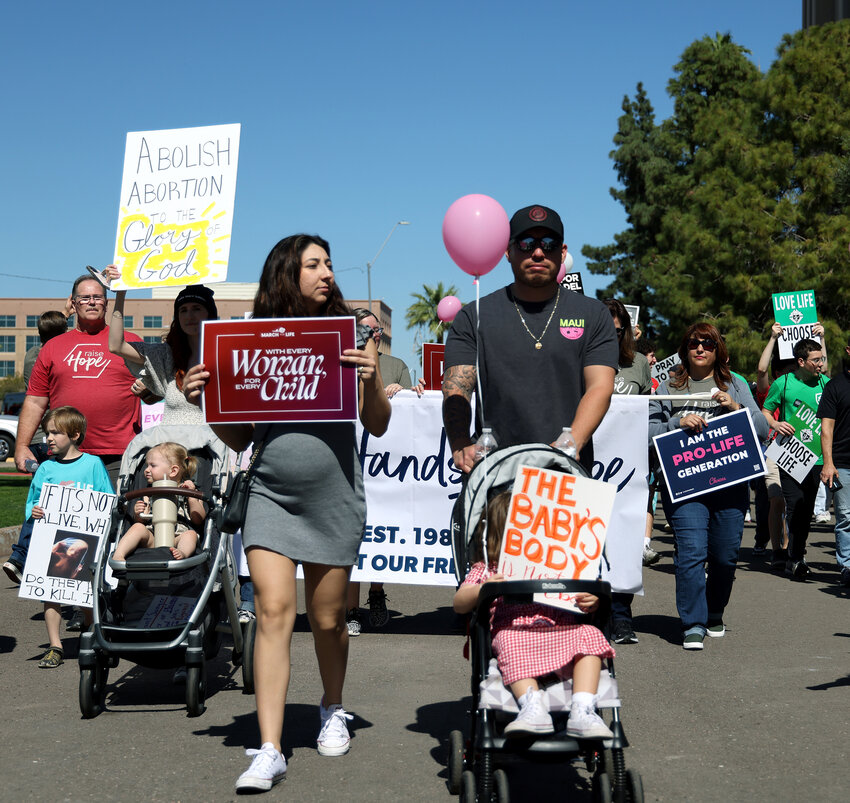 Marchers walk in front of the Executive Tower in Phoenix during the March for Life on March 1. Many of those at the march and rally brought their children. (Photo by Kevinjonah Paguio/Cronkite News)