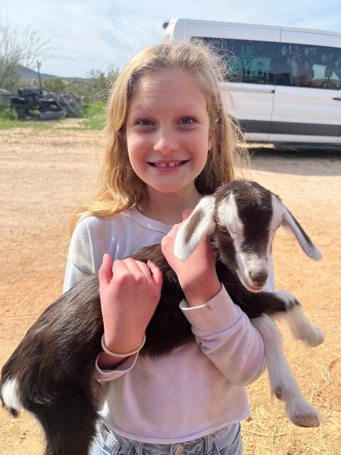 Sixth grader Ashlyn Robinson holds a baby goat.
