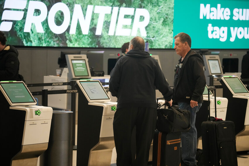 Travelers check in at the self-service ticketing kiosks for Frontier Airlines in Denver International Airport on Monday, Nov. 20, 2023, in Denver. (The Associated Press/David Zalubowski)
