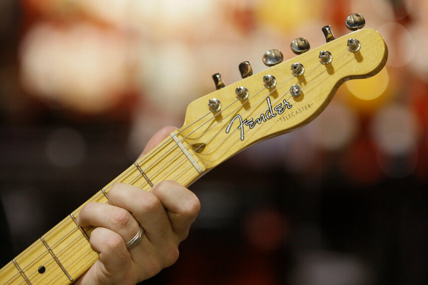 An employee plays a Fender Telecaster guitar at a Best Buy in Downers Grove, Ill., on Friday, July 25, 2008. (The Associated Press/M. Spencer Green)