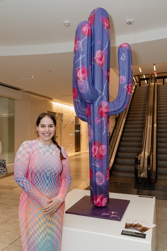 Scottsdale Fashion Square is exhibiting 10 life-size saguaro cactus sculptures from local artists through April 1. Scottsdale artist Paige Poppe posses with her sculpture, Swirls of Sonoran Stars