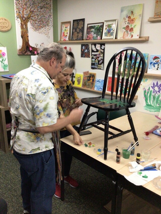 Members of the Benevilla Lucy Anne&rsquo;s Place Life Enrichment Day Program work with an artist from Ground Floor Artists to paint a chair.