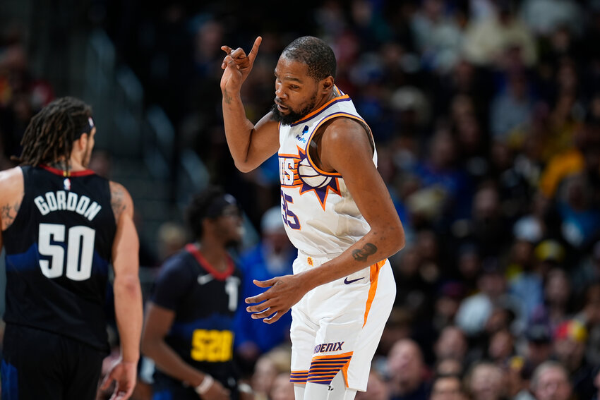 Phoenix Suns forward Kevin Durant gestures after hitting a 3-point basket against Denver Nuggets forward Aaron Gordon during the second half of an NBA basketball game Wednesday, March 27, 2024, in Denver.