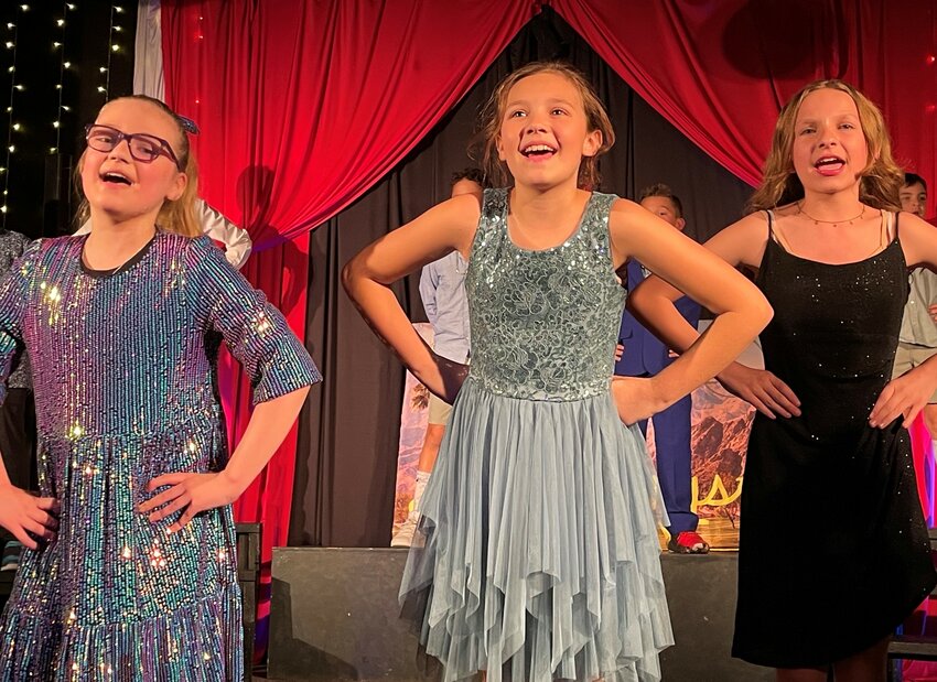 From left, Hayden Wheatman, Claire Robinson and Violet Wilson light up the stage at Paige Productions Youth Theater.