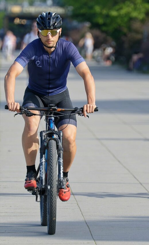 A man is shown riding a bicycle. The governing body approved a separate measure to apply for a federal grant to help improve its road safety within the city limits. The grant is from the Safe Streets and Roads for All Grant Program.