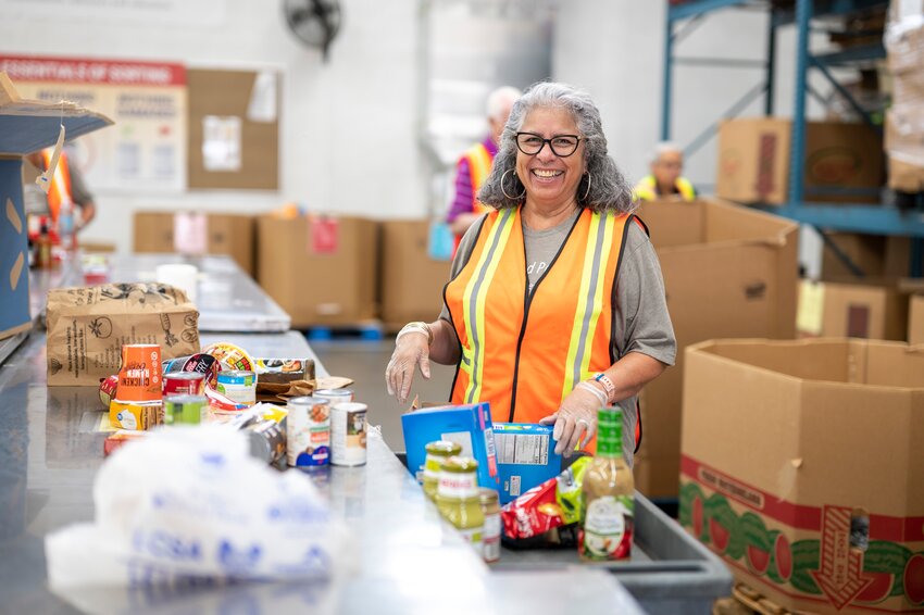 A St. Mary&rsquo;s volunteer helps sort food donations. St. Mary&rsquo;s is one of more than 1,000 organizations residents can donate to as part of Arizona Gives Day.