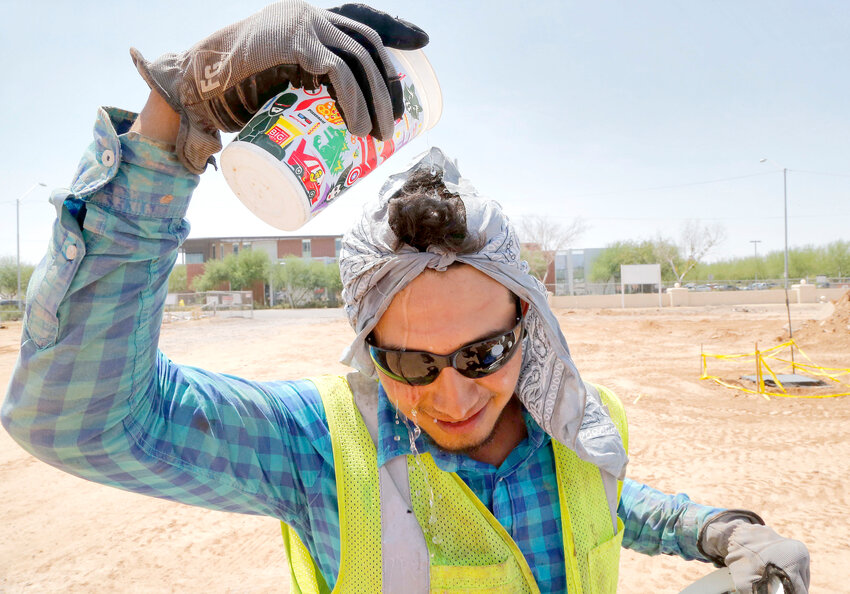 Construction worker Ruben Roman drips water on his head during his lunch break, Thursday, July 24, 2014, at a job site in Phoenix. (The Associated Press/Matt York)