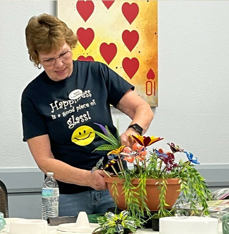 Pictured is club member Kathy Griffiths demonstrating to the club how to turn fused glass flowers into a potted garden.