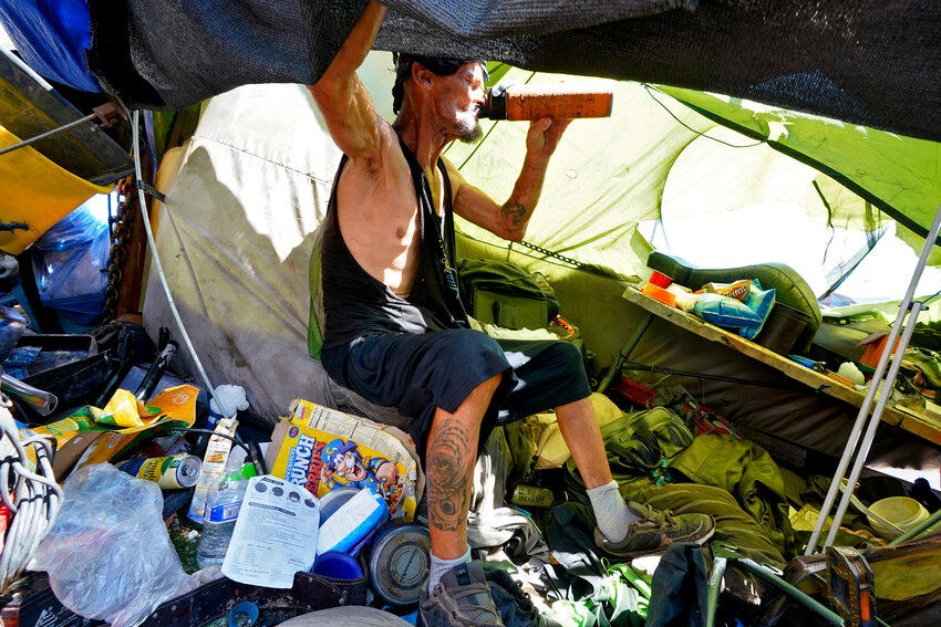 Charles Sanders, 59, sits in his tent inside a homeless encampment called &ldquo;The Zone,&rdquo; Friday, July 14, 2023, in downtown Phoenix. (The Associated Press/Matt York)