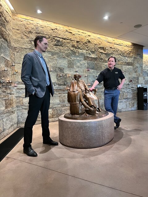The Casa's Ryan Sheade, director of counseling and licensed clinical social worker, and Executive Director Charlie Brown stand beside the statue of Saints Francis and Clare of Assisi in Our Lady of the Angels Church.