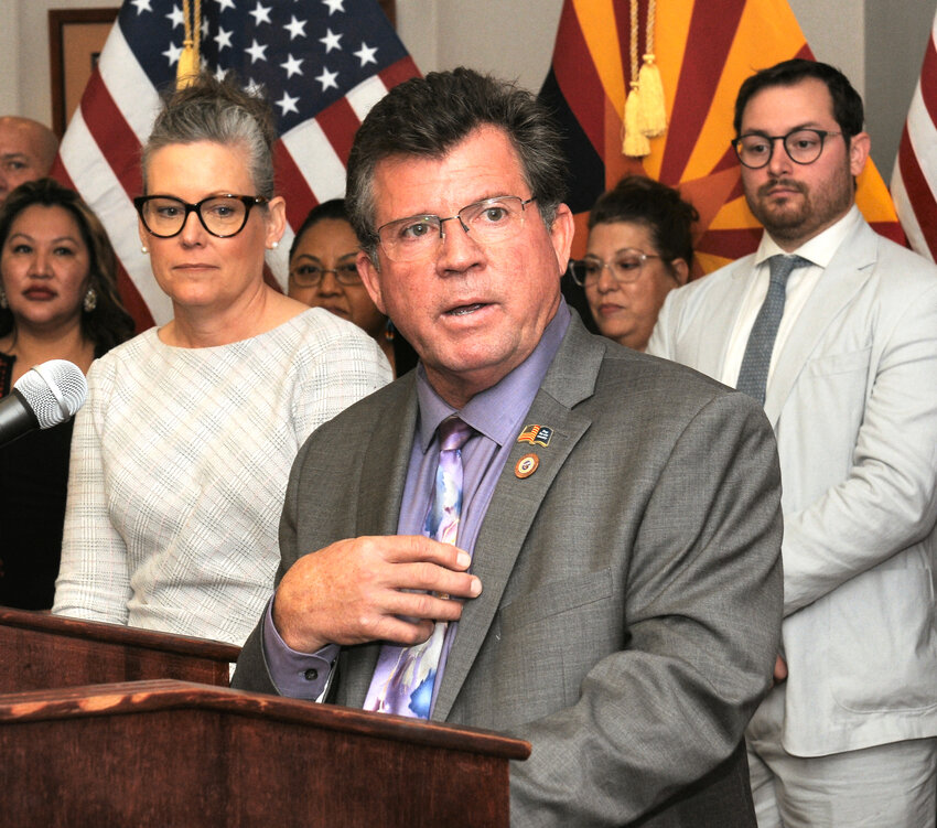 Rep. Tim Dunn answers questions Monday about legislation he crafted designed to crack down on assisted living facilities that put residents in danger of injury or death. With him is Gov. Katie Hobbs, front left, who signed the measure. (Capitol Media Services/Howard Fischer)