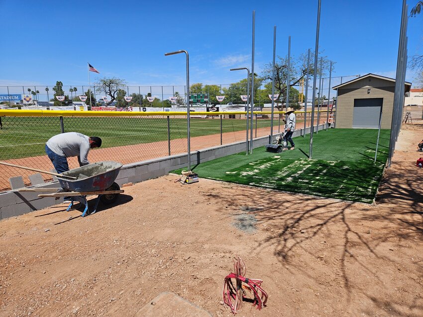 Contractors with Robert E. Porter Construction Company lay turf for the batting cage at Sun Bowl Softball Field April 8.