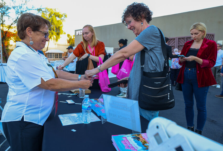 Guests get checked into the Phoenix Film Festival&rsquo;s opening night kickoff event at the party pavilion next to the Harkins Theatres: Scottsdale 101 on April 4, 2024. (Photo by Kayla Mae Jackson/Cronkite News)