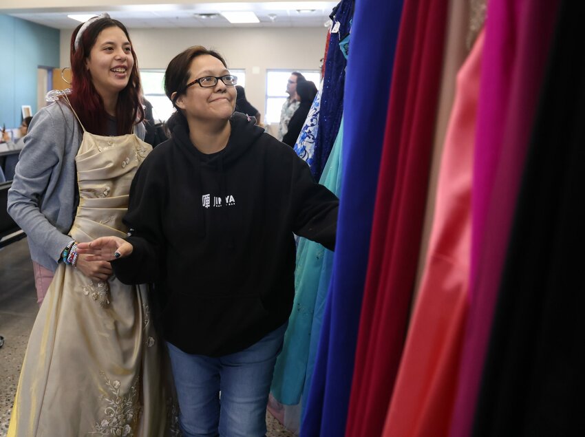 Zoe Jane Sandige, left, and her mother, Dacia Wagoner, look at a gold prom dress together at The Prom Closet in Glendale on April 6, 2024. (Photo by Lauren Kobley/Cronkite News)