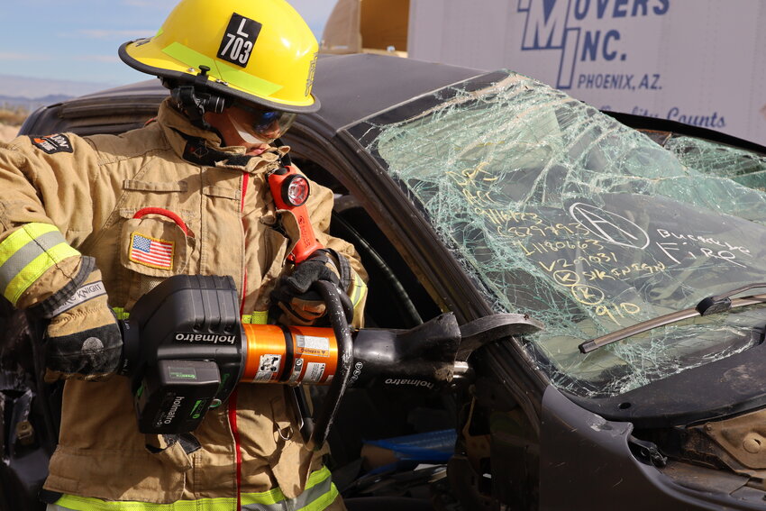 Firefighter uses extrication tool.