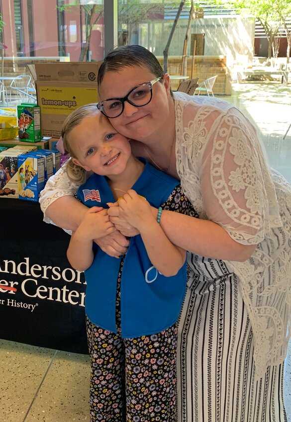 The Girl Scout troop of Juliet Crofton, left, donated Girl Scout cookies to Banner MD Anderson  Cancer Center to honor Juliet's mother, Lindsay Radcliffe, right, a patient there.