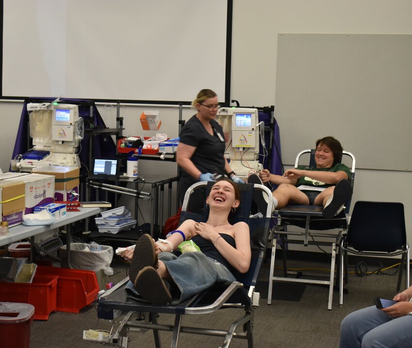 Siblings senior Olivia Melloy and sophomore Nathan Melloy share a laugh while donating blood. (Independent Newsmedia/George Zeliff)