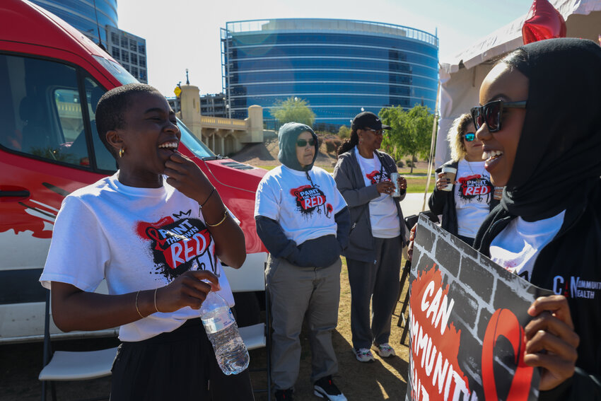 Grace Ashu, left, regional director of CAN Community Health, stands beside an AIDS testing truck during Aunt Rita&rsquo;s Paint the Town Red AIDS Walk Arizona &amp; 5K Run on April 6 at Tempe Beach Park. (Photo by Kayla Mae Jackson/Cronkite News)