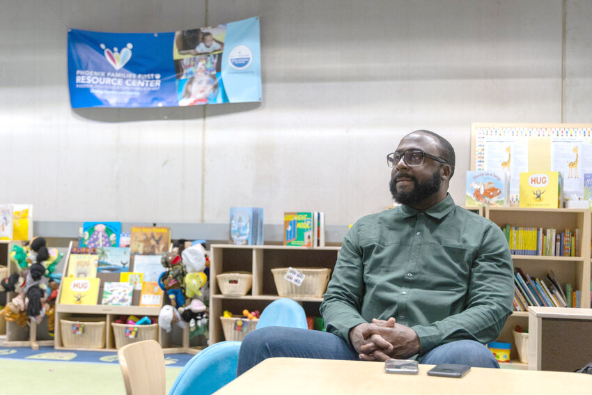 Lord Washington, a father support specialist for Dad Together, sits at one of the children&rsquo;s tables in the Phoenix Families First Resource Center in the Burton Barr Central Library. Washington is a Dad Together alum and now leads classes. Photo taken in Phoenix on April 8, 2024. (Photo by Emily Mai/Cronkite News)
