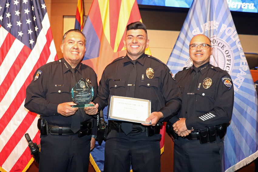 Surprise Police Chief Benny Pina, left, presents officer Edwin Herrera, center, with the department&rsquo;s Officer of the Year award.