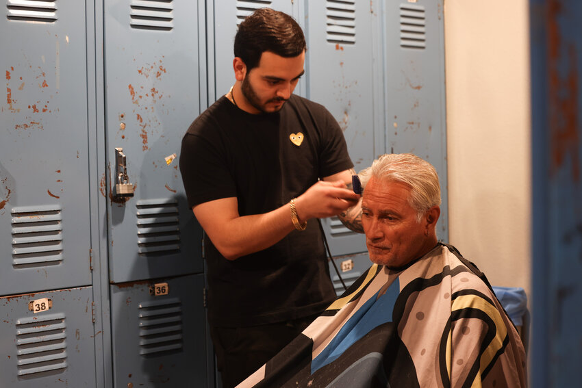 Robert Chayrez gets a haircut from Adriel Romano. Chayrez says he&rsquo;s been coming to Justa Center for four years and has been able to get biweekly haircuts from volunteers. (Photo by Crystal N. Aguilar/Cronkite News)