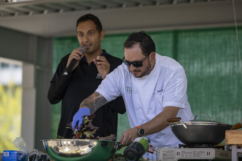 Chef Matthew Padilla, True Food Kitchen&rsquo;s senior vice president of culinary, mixes a salad with ingredients from the Downtown Phoenix Farmers Market as Dr. Shad Marvasti explains the health benefits of different ingredients at the Health &amp; Wellness Phoestival on April 13, 2024. (Photo by Sam Ballesteros/Cronkite News)