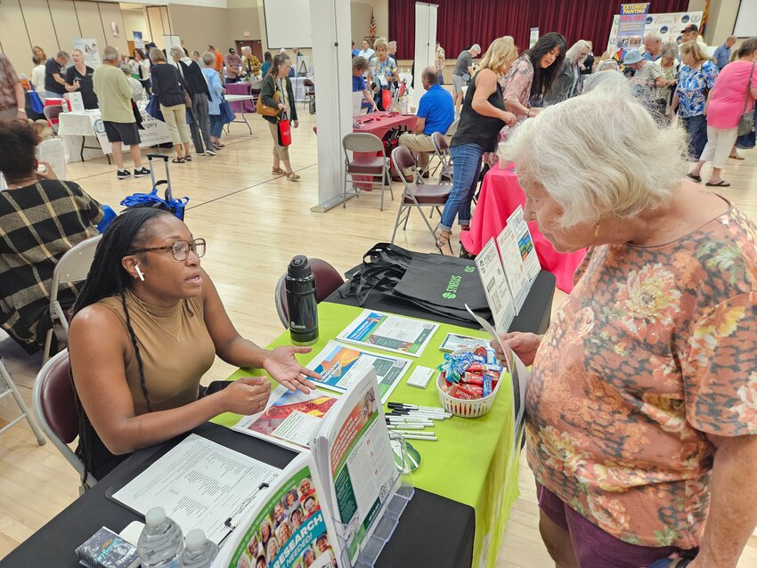 Tamir McElrath explains Synexus to Catherine Ozment during the Sun City Senior Expo May 6 at Sundial Recreation Center.