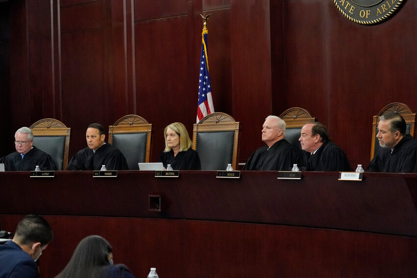 Arizona Supreme Court Justices from left, William G. Montgomery, John R Lopez IV, Vice Chief Justice Ann A. Scott Timmer, Chief Justice Robert M. Brutinel, Clint Bolick and James Beene listen to oral arguments on April 20, 2021, in Phoenix. Two groups have joined a fight in the state to try to oust the two justices who are up for reelection. (Associated Press/Matt York)