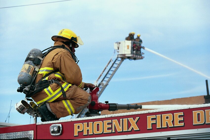 Phoenix firefighters put out a fire. The department is adding more fire stations to serve the growing city, but the number of recruits has dropped drastically during the past decade, resulting in staffing shortages and long response times. (Courtesy city of Phoenix)