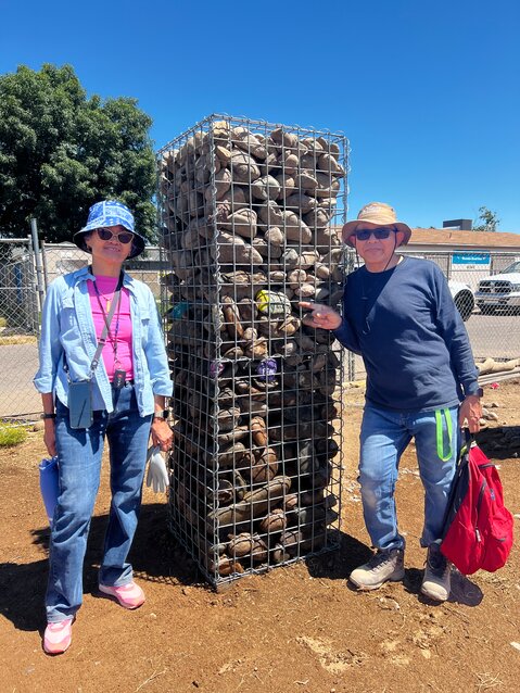 Volunteers for Family Promise of Greater Phoenix stand next Gabion Wall made of wire and stones to enclose the Family Promise Village in Glendale.