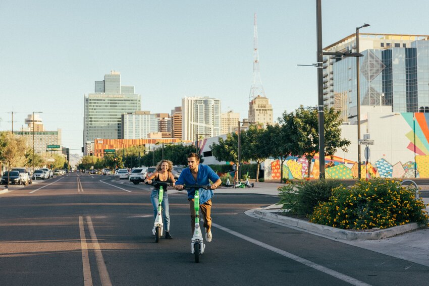 A man and woman ride motorized scooters in downtown Phoenix. (Courtesy Visit Phoenix)