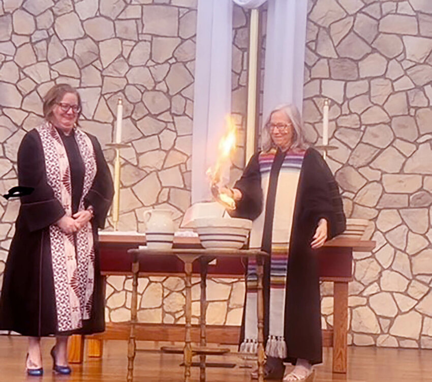 Chandler United Methodist Church pastor Candace Lansberry, right, burns CUMC&rsquo;s mortgage as part of an April 27 ceremony.