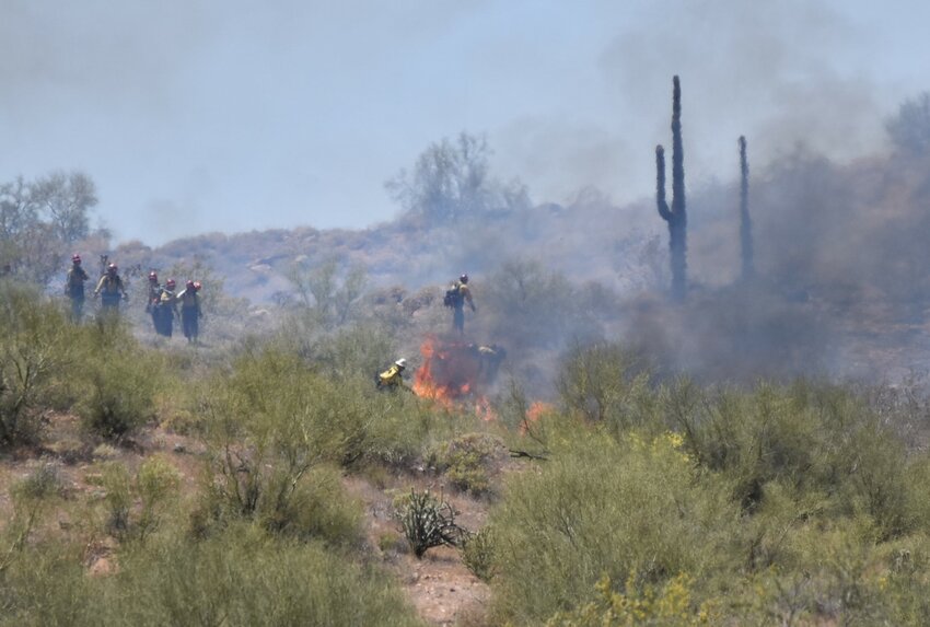 Firefighters spread out across the desert to attack a brush fire just outside the Fountain Hills boundary on the Salt River Pima Maricopa Indian Community.