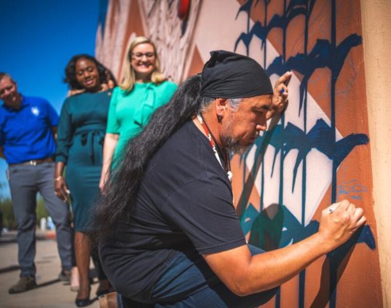 From right, Artist Thomas &ldquo;Breeze&rdquo; Marcus signs his mural at the S&rsquo;edav Va&rsquo;aki Museum as Mayor Kate Gallego and Councilmember Kesha Hodge-Washington look on. (Courtesy city of Phoenix)