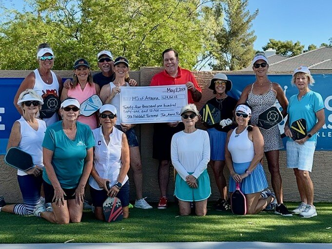 Jim and Annie Kloss present a check of $24,161 from their MS charity pickleball tournament.