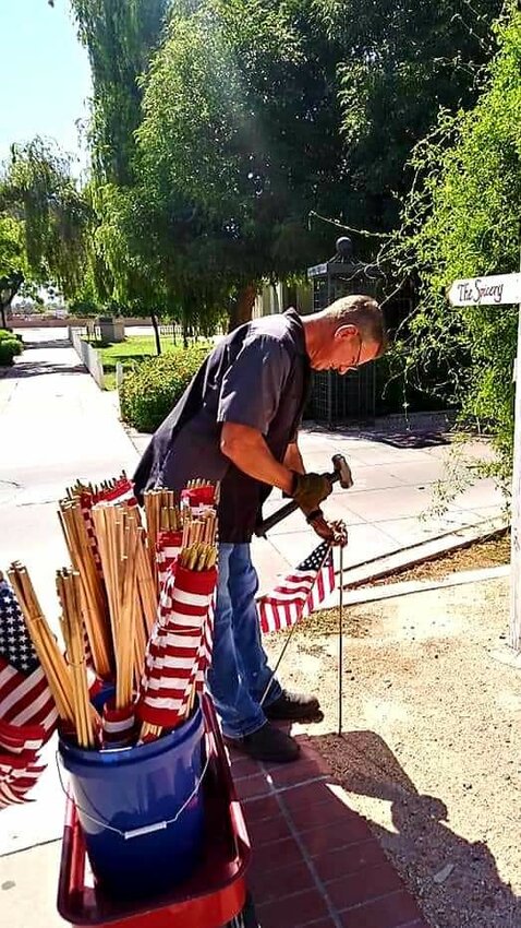 Coit Burner from Bears &amp; More in downtown Glendale installs flags all around the Catlin Court are before Memorial Day.