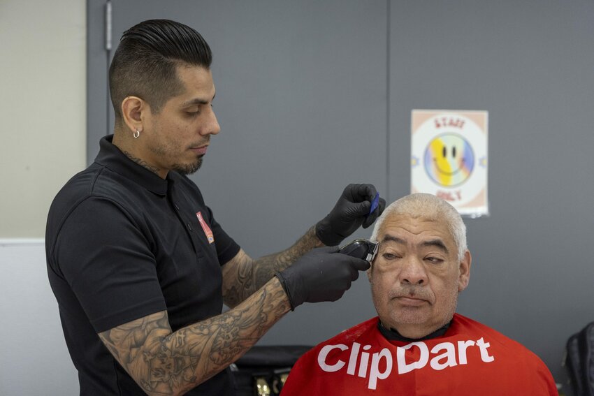 David Rodriguez trims Daniel Holguin&rsquo;s hair at the Glendale Community Center on April 8, 2024. (Photo by Sam Ballesteros/Cronkite News)