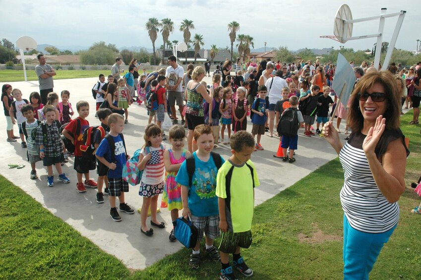 Elementary school students line up outside before the first day of school. (file photo)