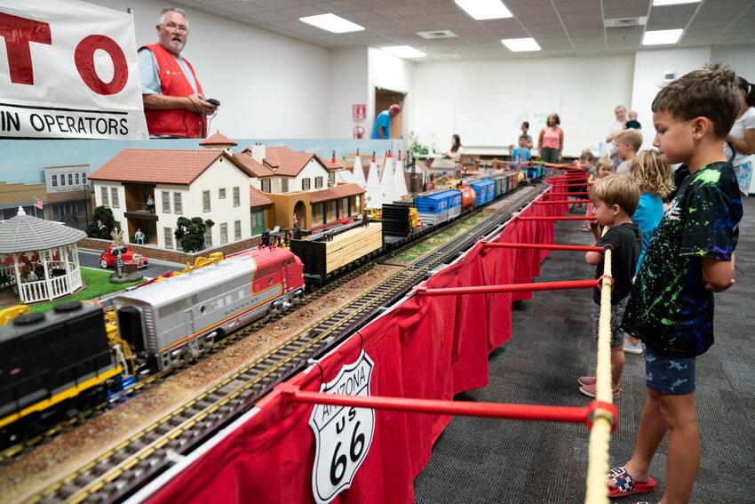 Kids watching operators from The Arizona Big Train Operators model train club operate their model railroad display.