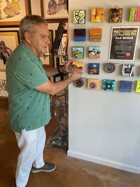 Artist Jim Rapisarda inspects the Mini Art wall currently on display at The Fountain Hills Artists’ Gallery.