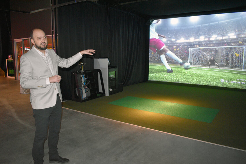 Uptown Alley General Manager Adam Dufur shows off one of the two new sports simulators that feature 30 games that players can choose.
